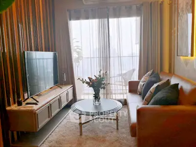 Stylish living room with modern decor and large window offering natural light.