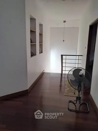 Spacious hallway with wooden flooring and modern decor in a stylish home.