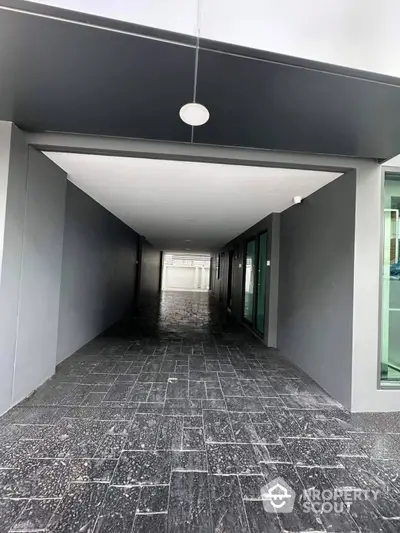 Modern building entrance with sleek design and dark tiled flooring