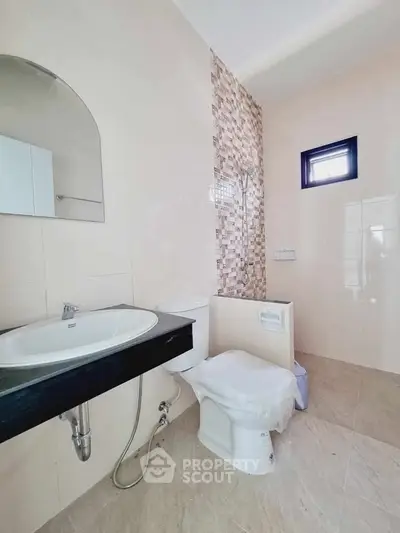 Modern bathroom with stylish sink and tiled wall accent