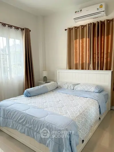 Cozy bedroom with elegant decor and natural light, featuring a comfortable bed and stylish curtains.
