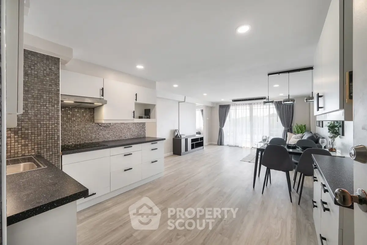 Spacious open-plan kitchen and living room with modern design and ample natural light.