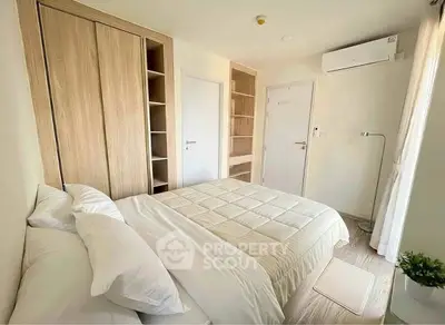Cozy modern bedroom with built-in wardrobe and air conditioning in a bright apartment.