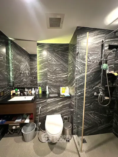 Luxurious modern bathroom with sleek black marble walls and high-end fixtures.