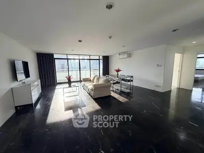 Spacious modern living room with city view, sleek black flooring, and elegant furnishings.
