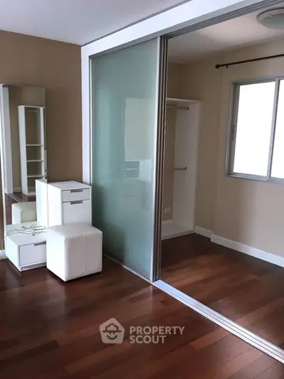 Modern bedroom with wooden flooring and sliding glass closet doors