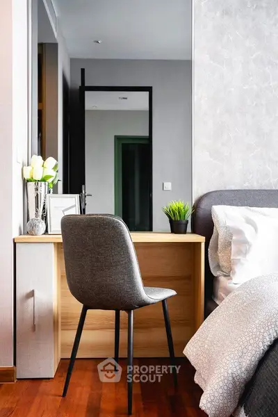 Modern bedroom with stylish desk and chair, elegant decor, and cozy ambiance.