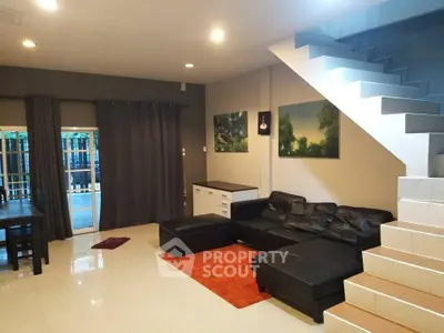 Spacious living room with modern decor and staircase, perfect for family gatherings.