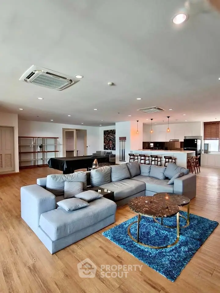 Spacious modern living room with open kitchen and stylish furniture, perfect for entertaining.