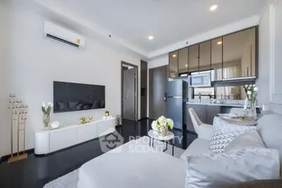 Modern living room with open kitchen, stylish decor, and cozy seating area.