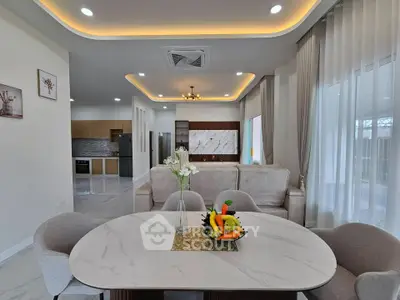 Luxurious open-plan living and dining area with modern decor and elegant lighting.
