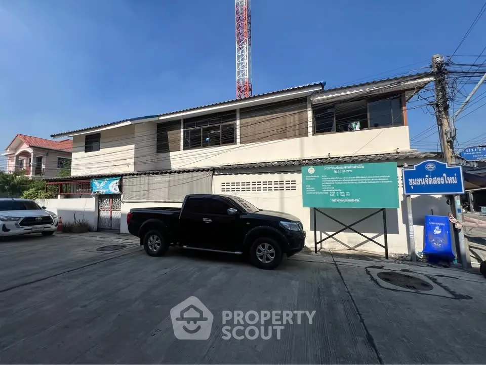 Modern two-story building with parking area and clear blue sky