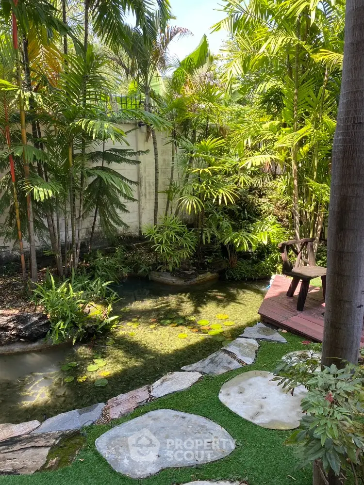 Tranquil garden with lush greenery and serene pond in a residential setting