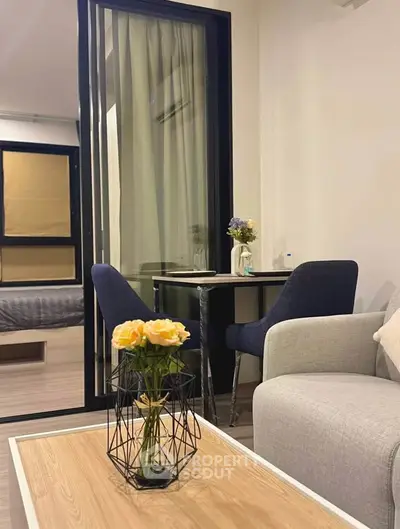 Modern living room with stylish furniture and elegant decor, featuring a cozy seating area and a small dining table.