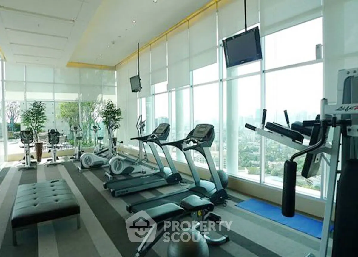 Luxurious high-rise gym with panoramic city views and modern fitness equipment.