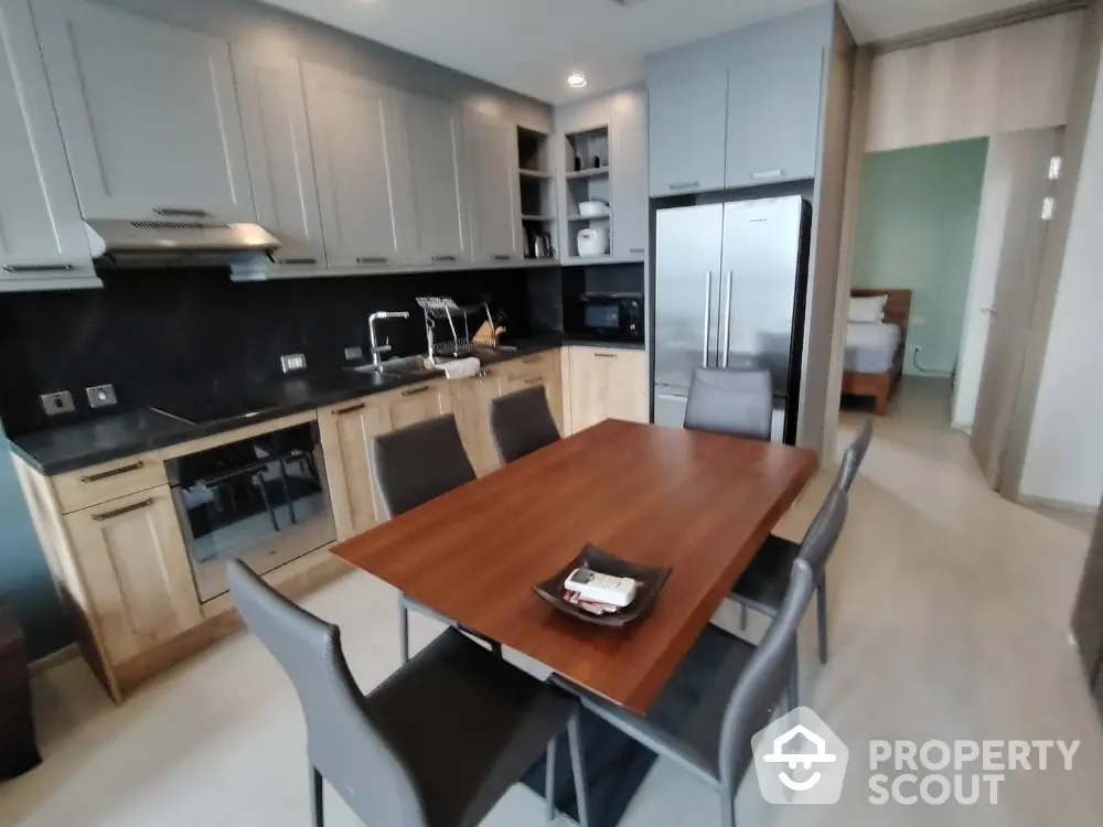 Modern kitchen with sleek cabinetry and dining area in stylish apartment