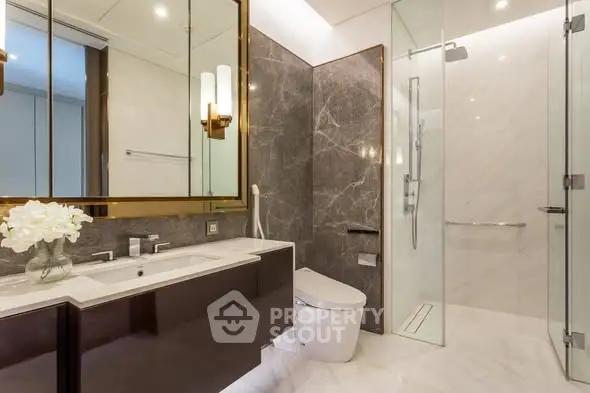 Luxurious modern bathroom with marble accents and glass shower enclosure.