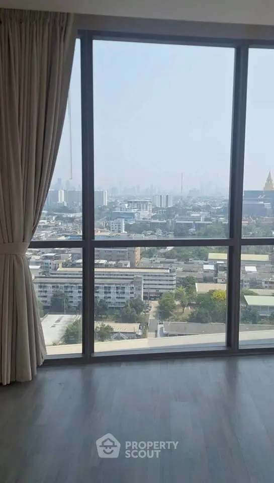 Stunning high-rise apartment view with floor-to-ceiling windows overlooking cityscape.