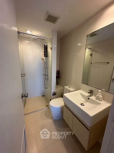 Modern bathroom with sleek fixtures and spacious shower in a contemporary apartment.