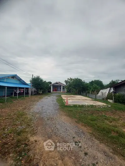 Charming countryside home with spacious driveway and lush greenery, perfect for serene living.