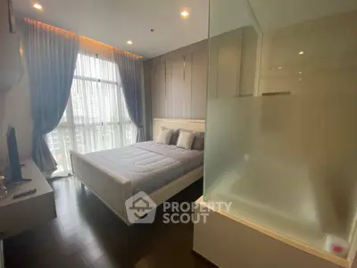 Modern bedroom with large window and stylish decor in high-rise apartment.