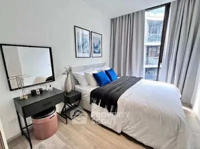 Modern bedroom with stylish decor and large window offering natural light.