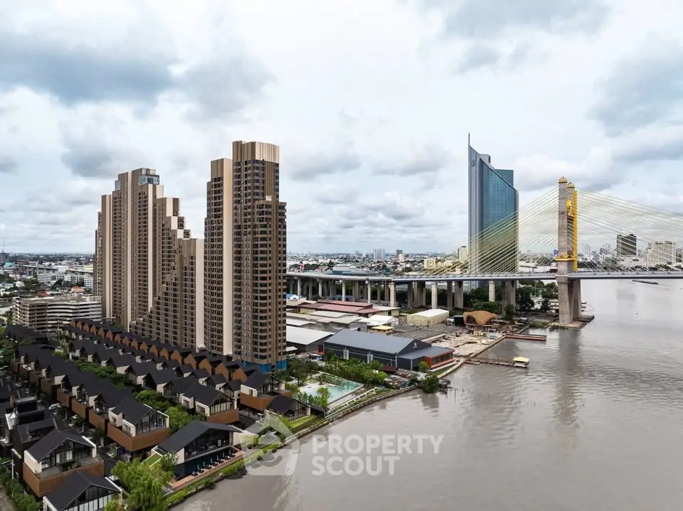 Stunning riverside high-rise buildings with modern architecture and scenic bridge view.