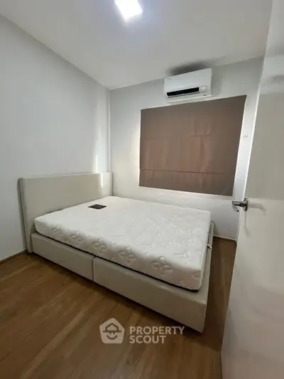 Modern bedroom with minimalist design featuring a comfortable bed and air conditioning.