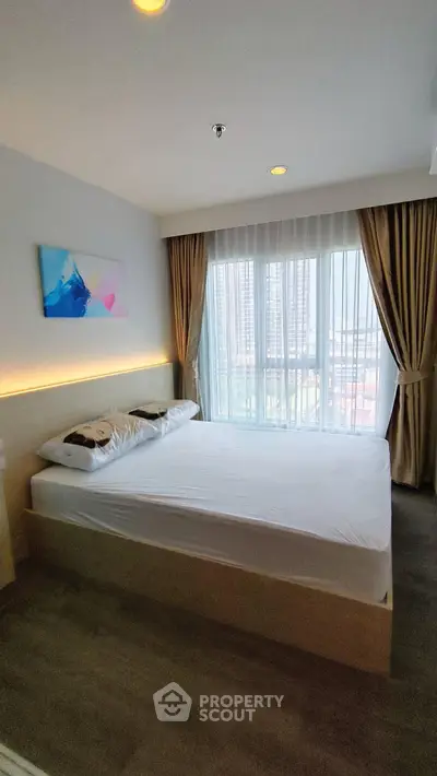 Modern bedroom with large window and city view, featuring stylish decor and natural light.
