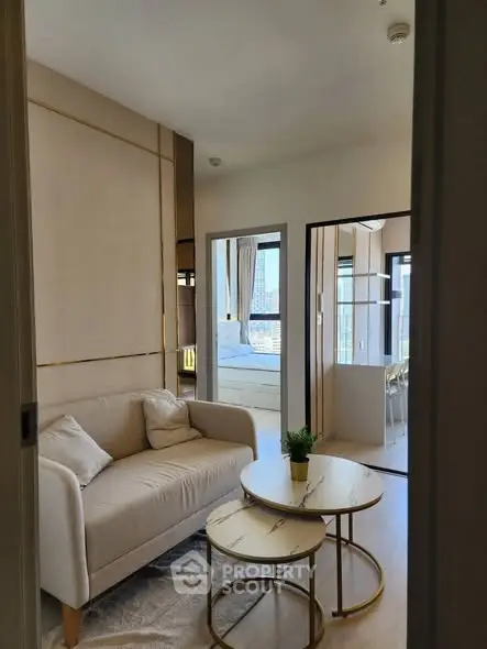 Modern living room with cozy sofa and stylish decor in a bright apartment with city view.