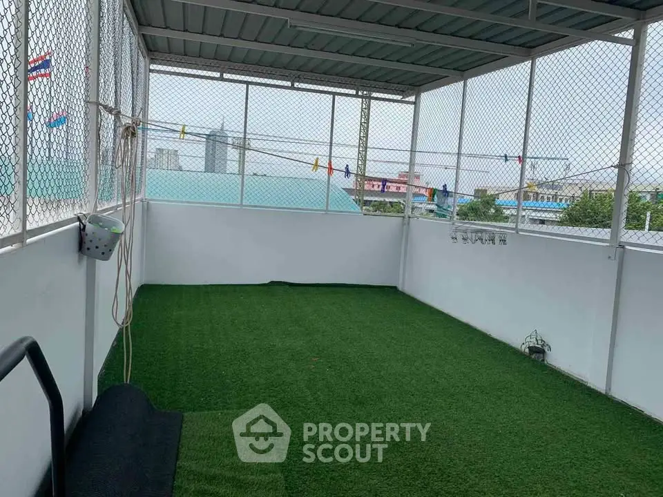 Spacious rooftop terrace with artificial grass and city views, perfect for relaxation and outdoor activities.