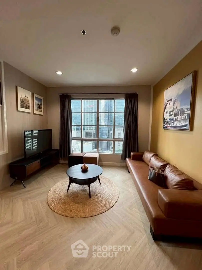 Stylish living room with leather sofa and city view, perfect for modern urban living.