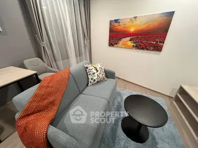 Modern living room with stylish decor and sunset artwork, featuring a cozy gray sofa and elegant furnishings.