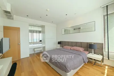 Spacious modern bedroom with hardwood floors and stylish decor