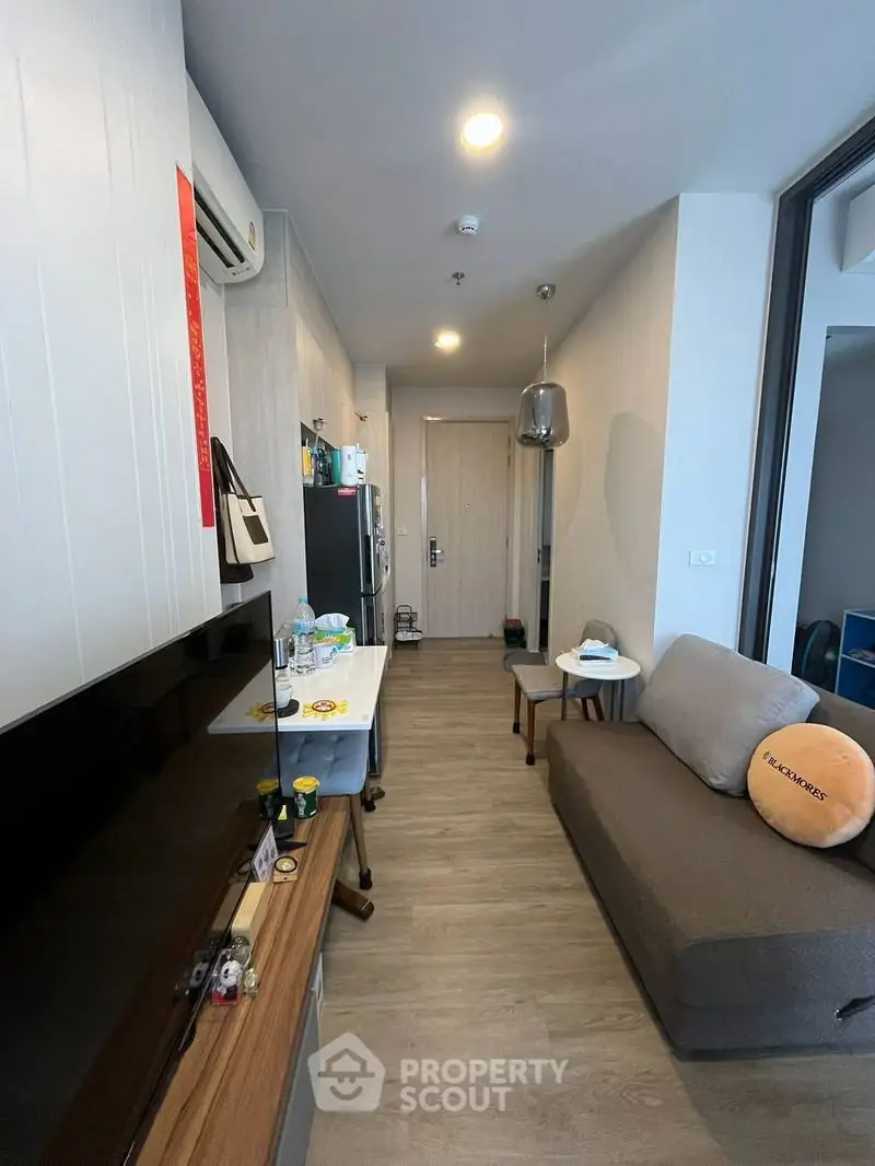 Modern living room with sleek furniture and wooden flooring in a cozy apartment.