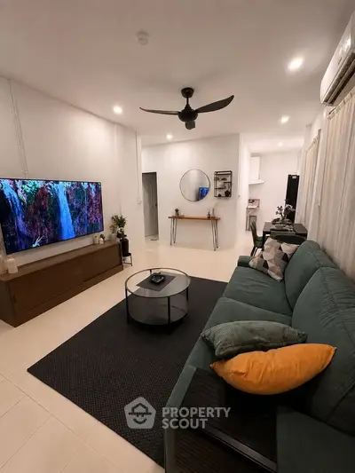 Modern living room with sleek furniture and large TV, perfect for relaxation and entertainment.