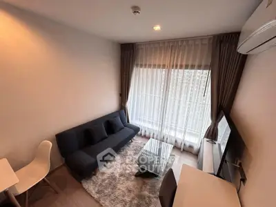 Modern living room with cozy sofa, stylish decor, and large window for natural light.