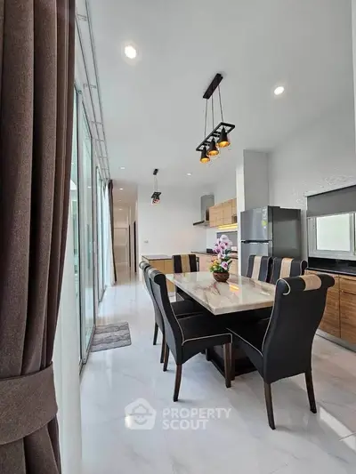 Modern kitchen with dining area featuring sleek design and elegant lighting