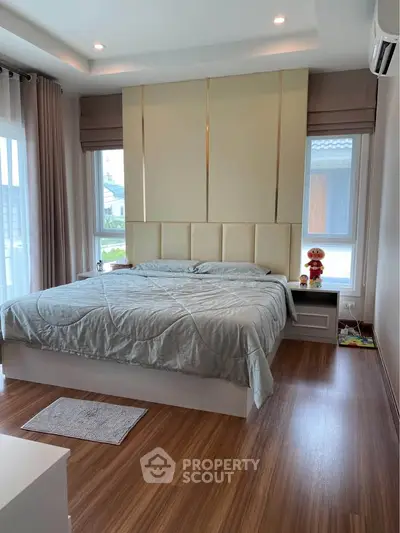 Spacious bedroom with modern design and large windows for natural light.