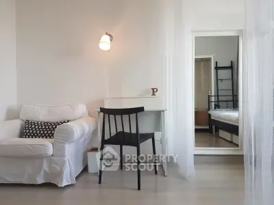Cozy modern living room with white sofa and sleek desk, perfect for urban living.