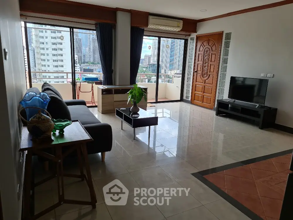 Spacious living room with city view, modern furniture, and large windows in urban apartment.