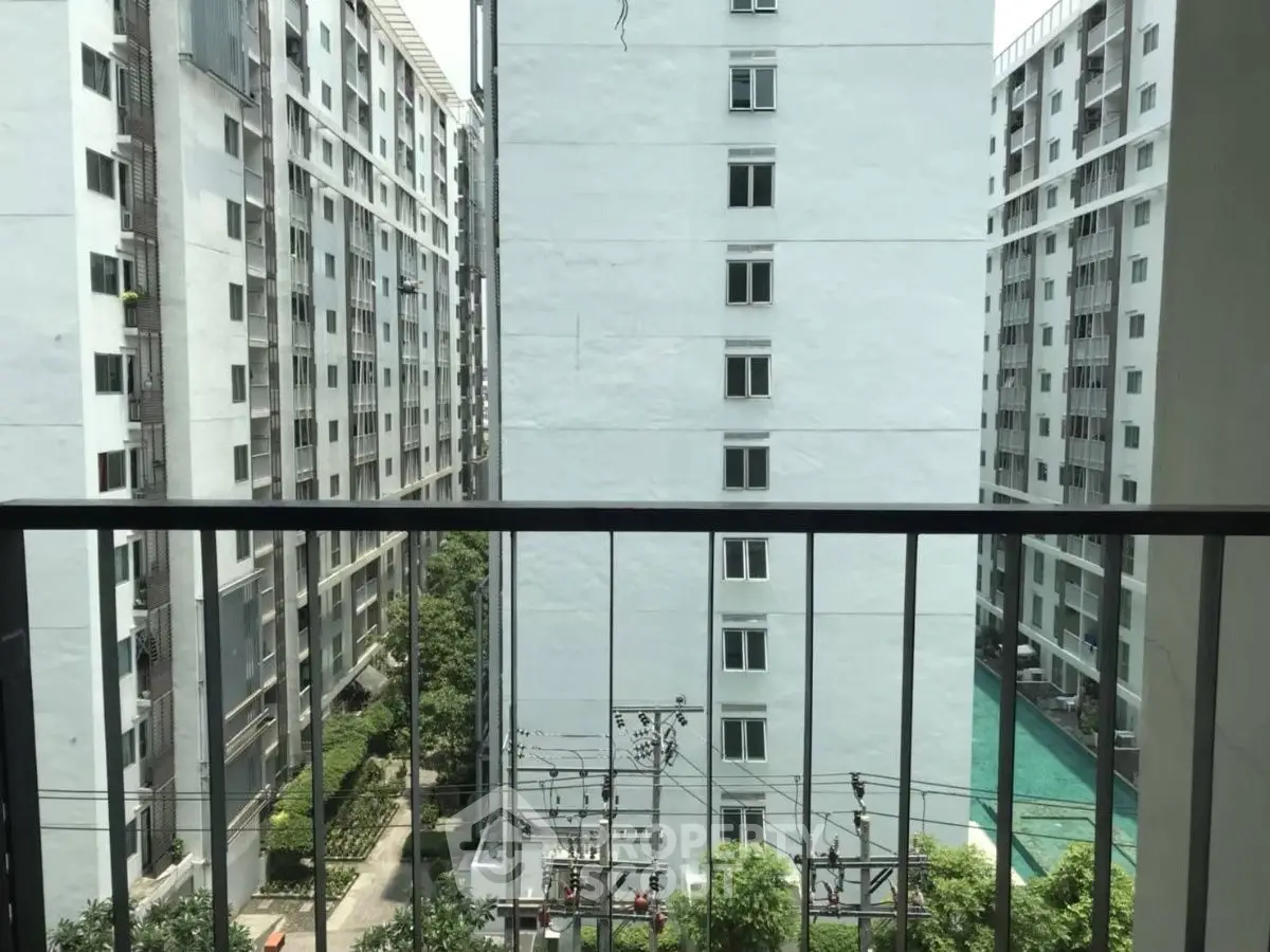 High-rise apartment view with pool and garden from balcony