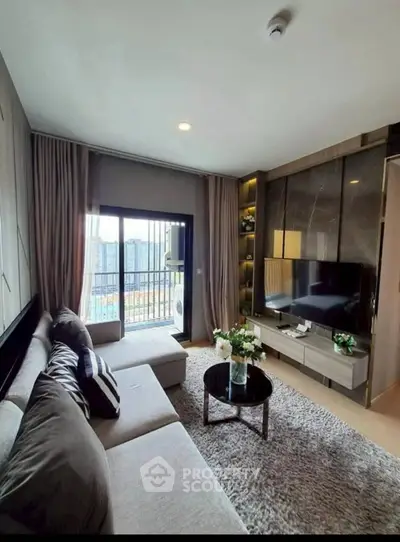 Modern living room with cozy sectional sofa and large TV, featuring a balcony view.