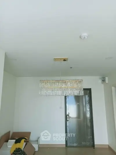 Modern interior with elegant chandelier and sleek door in minimalist room.