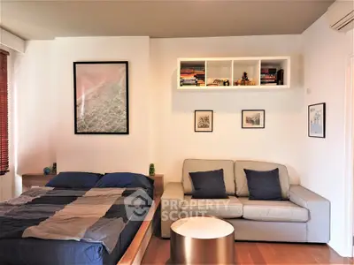 Cozy bedroom with modern decor, featuring a comfortable bed and stylish sofa, perfect for relaxation.