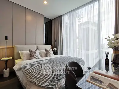 Luxurious bedroom with modern decor and large window offering city view.