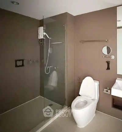 Modern bathroom with glass shower and sleek fixtures in contemporary apartment.