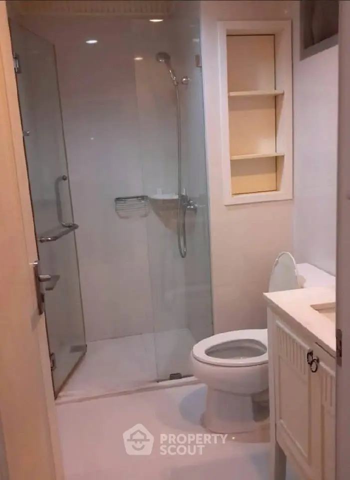Modern bathroom with glass shower and sleek fixtures in a contemporary home.