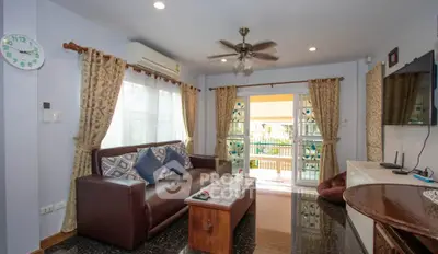 Charming living room with elegant decor and balcony access, featuring a cozy sofa and stylish curtains.