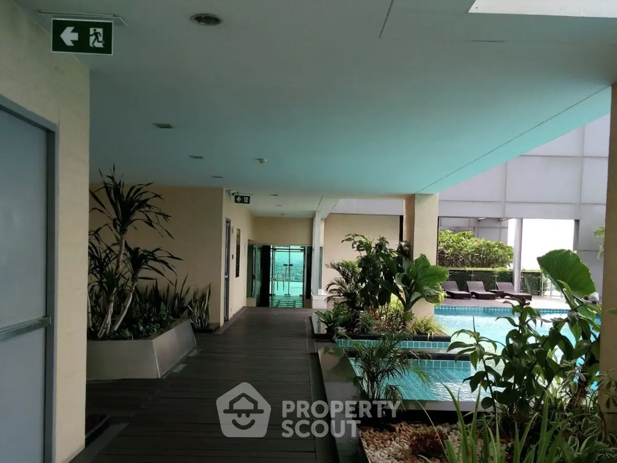 Luxurious apartment building with poolside view and lush greenery